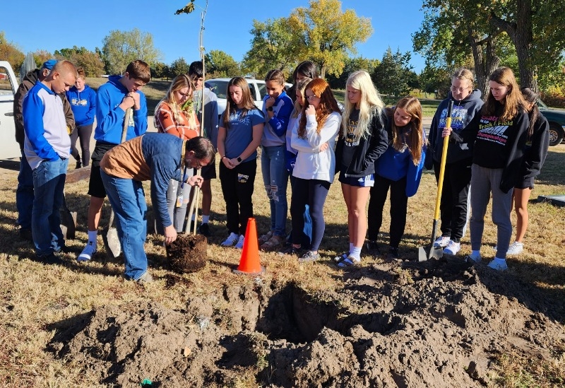 West Holt Public Schools Agriculture Teacher David Gibbens demonstrates how to prepare a tree for planting to his freshman students.
